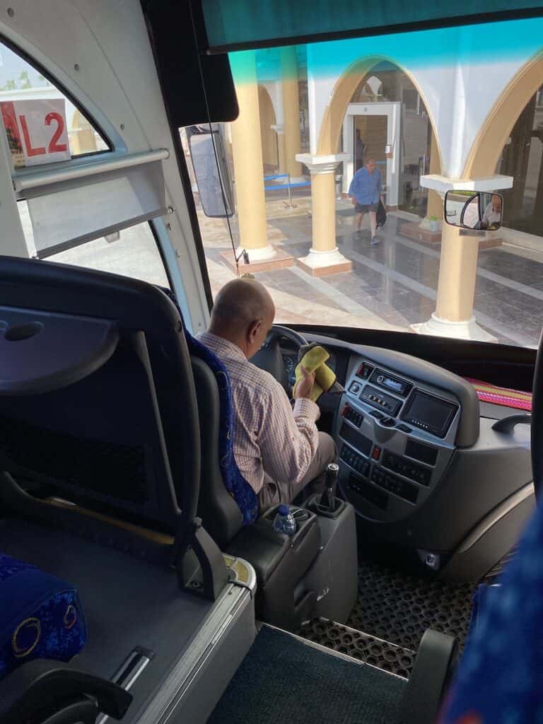 Bus driver wiping down steering wheel