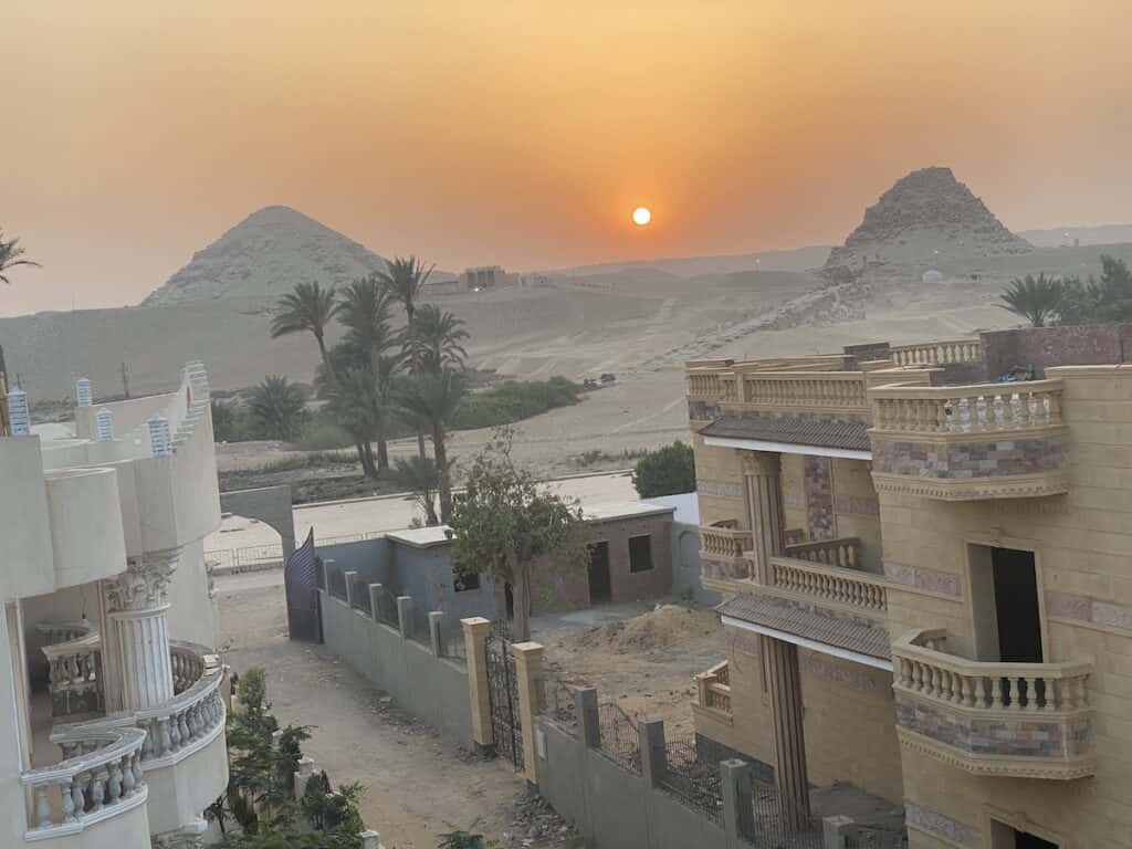 sun setting between two pyramids