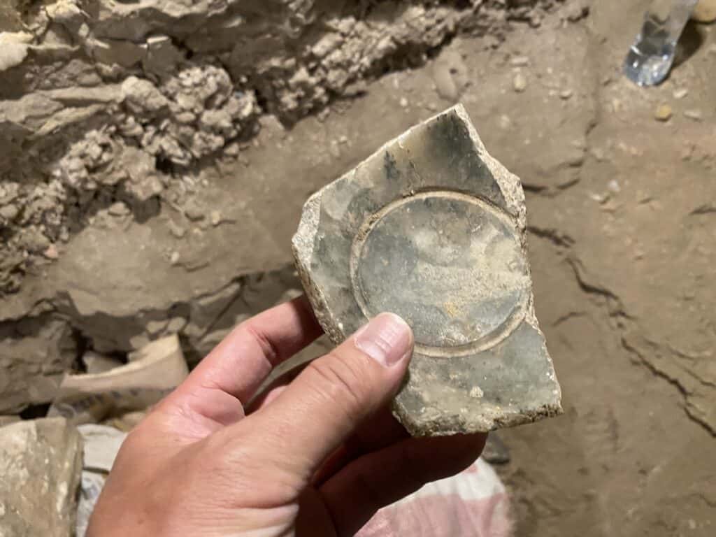 Holding a stone jar fragment