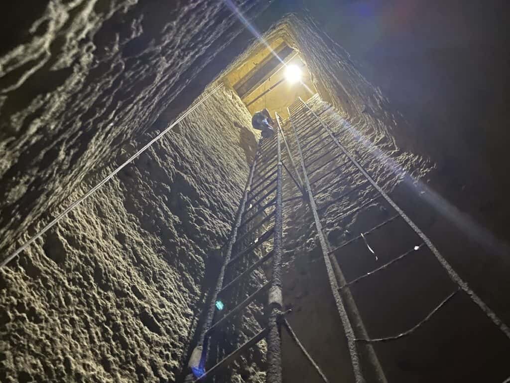 Climbing down ladder to second level of the Osiris Shaft