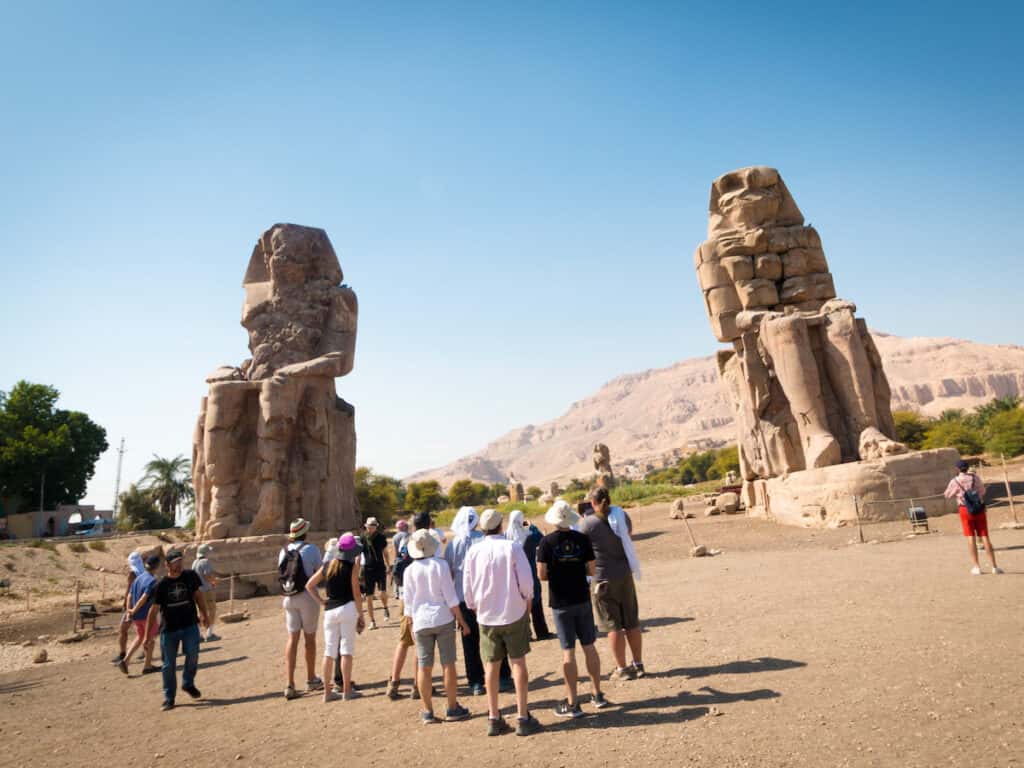 colossi of memnon with people in front