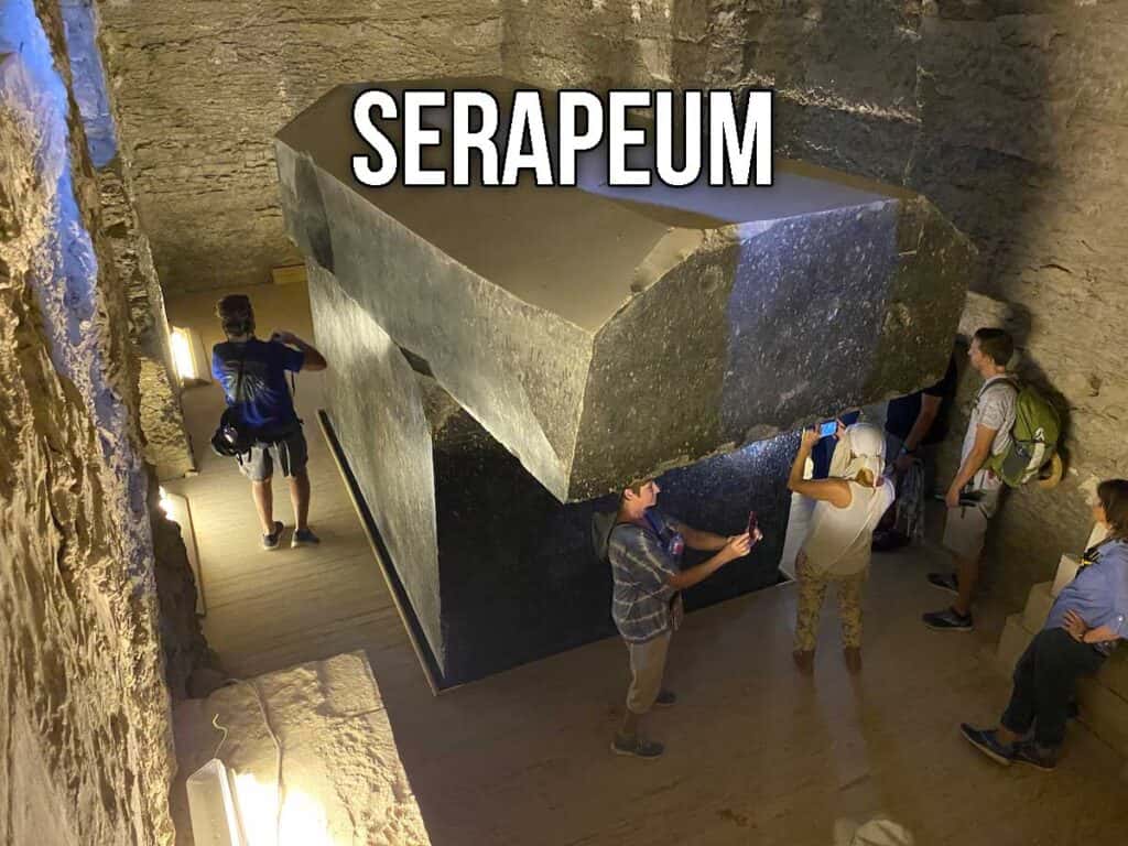 People inspecting the large stone box at the Serapeum.