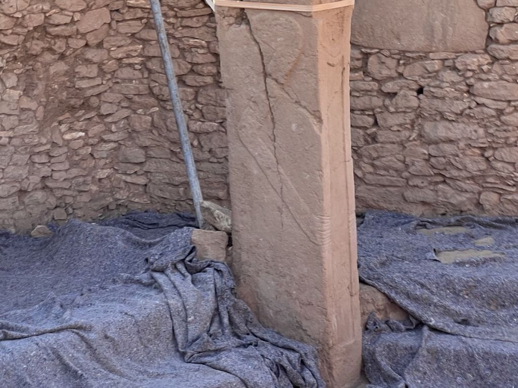 t-shape pillar showing arms with eight fingers