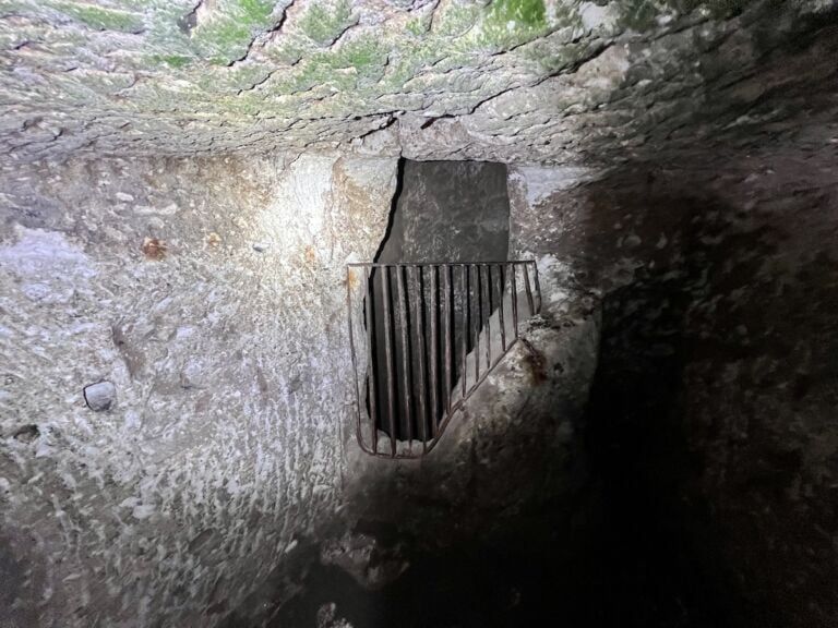 Door to a deep pit, with a railing