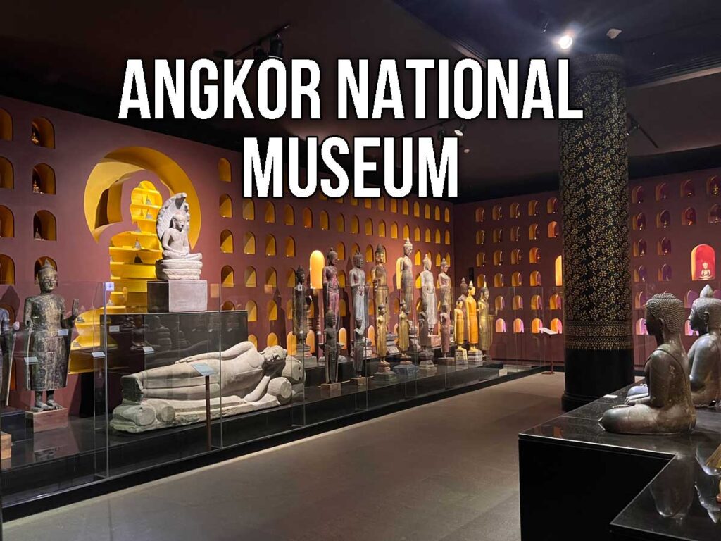 Exhibit hall inside the Angkor National Museum displaying rows of ancient Khmer statues, including reclining Buddhas and standing figures, lit against a backdrop of arched wall niches.