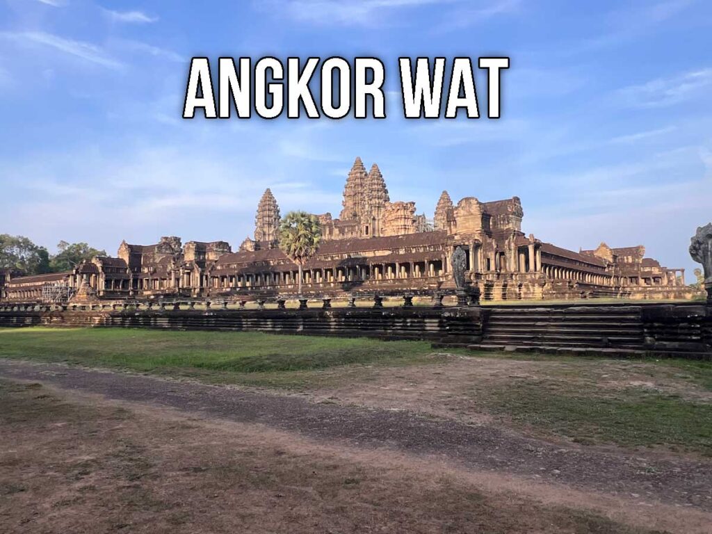 Wide daytime view of Angkor Wat’s central towers and galleries, with clear blue sky above and warm sunlight highlighting the sandstone architecture.