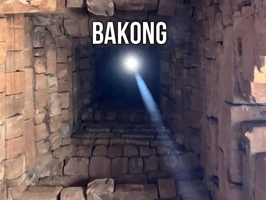 A beam of sunlight enters through the top of a vertical stone shaft inside Bakong Temple, illuminating the interior chamber during the zenith passage.