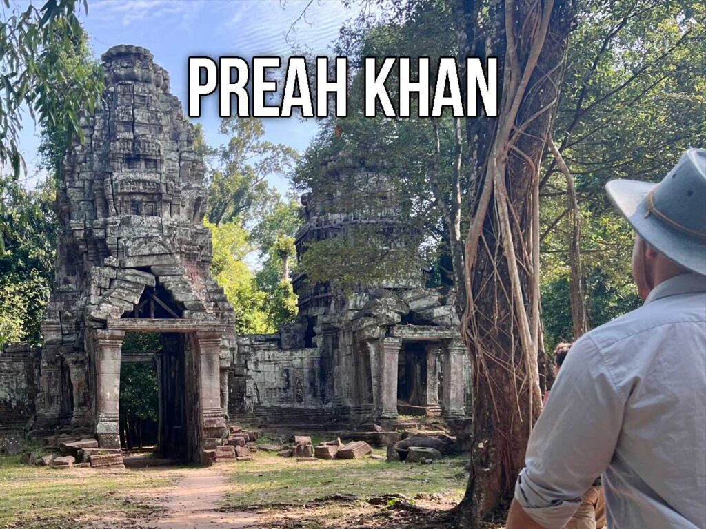 View of the towering entrance gate of Preah Khan temple, with weathered stone carvings and jungle trees surrounding the ancient structure.