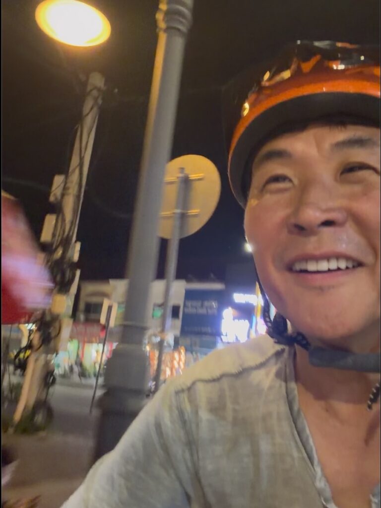 The author in an orange cycling helmet riding back to Siem Reap after dark