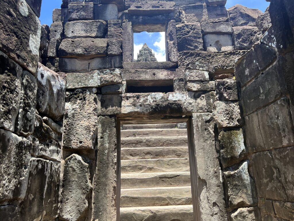 Bakong's central tower framed by a stone doorway at the top of a staircase
