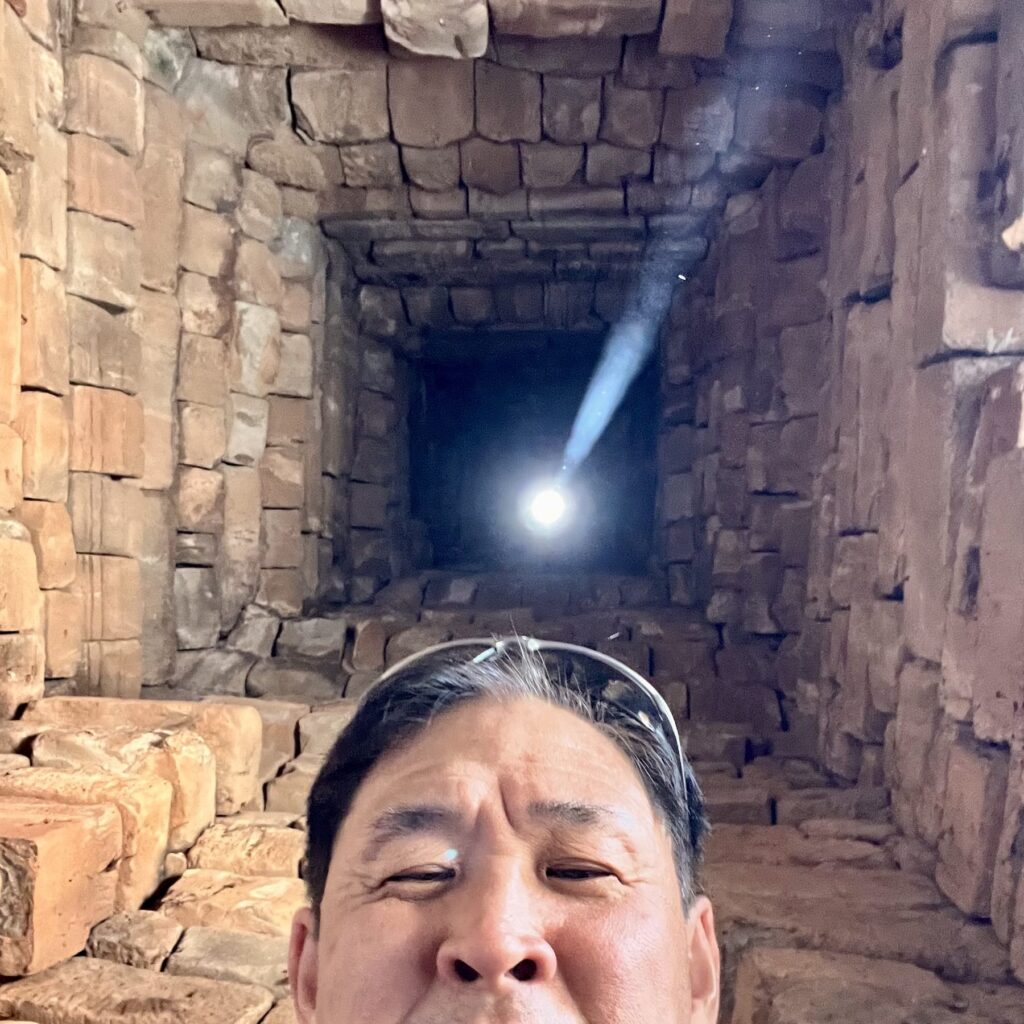 The author's selfie under Bakong's tower opening in April, with the sunbeam already slanting after solar noon
