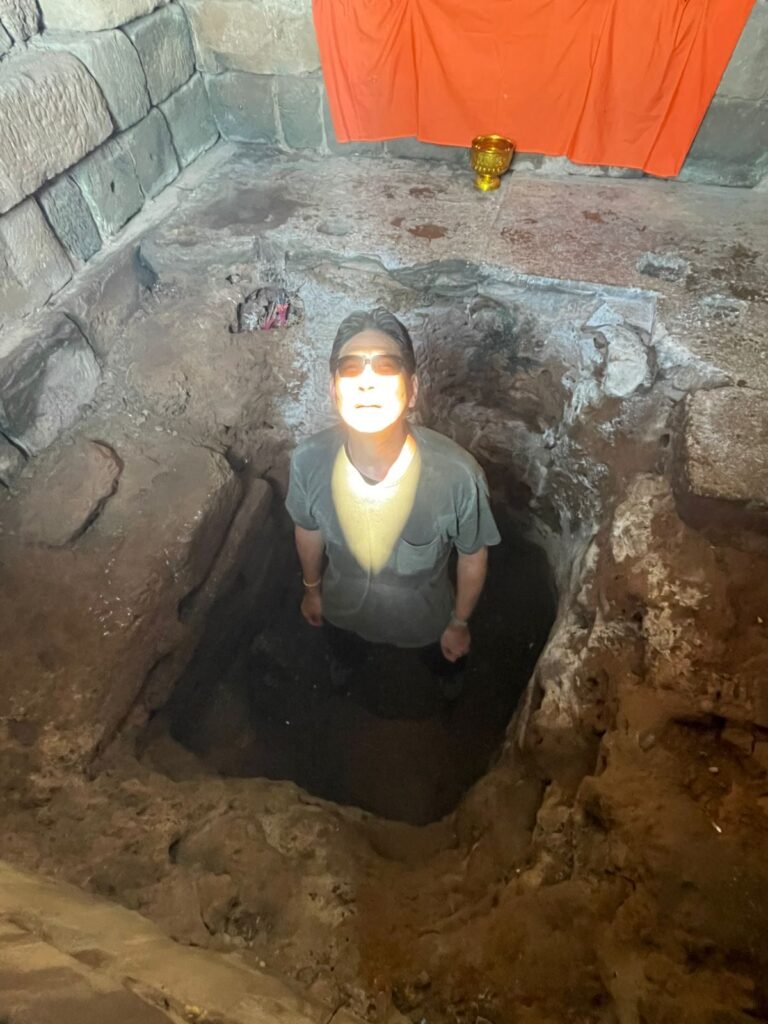 The author standing in the floor pit of Bakong's central sanctuary with the zenith sun lighting his face