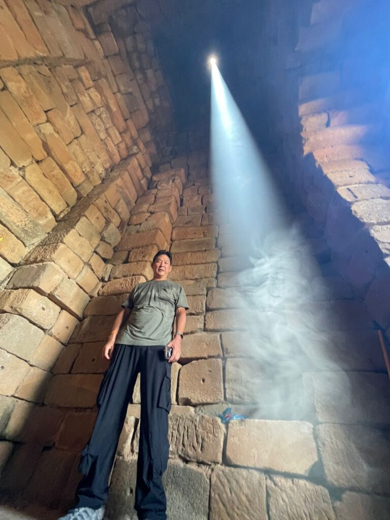 The author standing inside Bakong's central sanctuary beside the zenith sunbeam