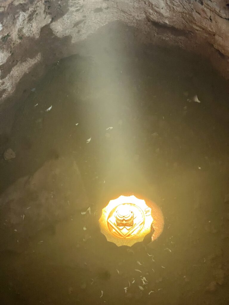 The zenith sunbeam landing on a golden offering at the bottom of the pit in Bakong's central sanctuary