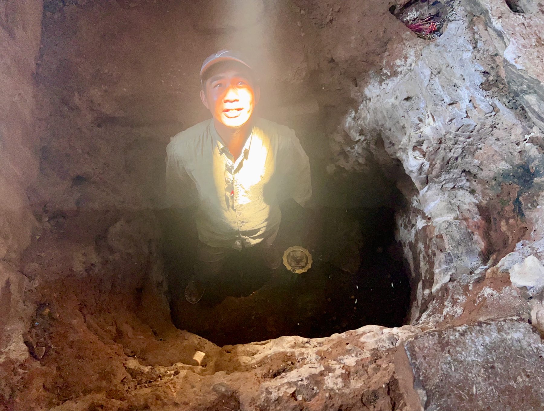 Guide Kanha Phum standing in the floor pit of Bakong's central sanctuary with the zenith sunbeam lighting his face