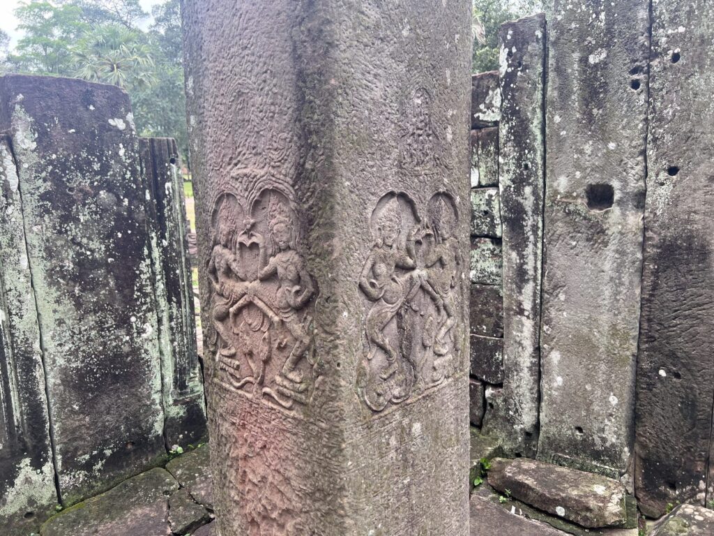 Carved apsara figures on a stone pillar at the Bayon