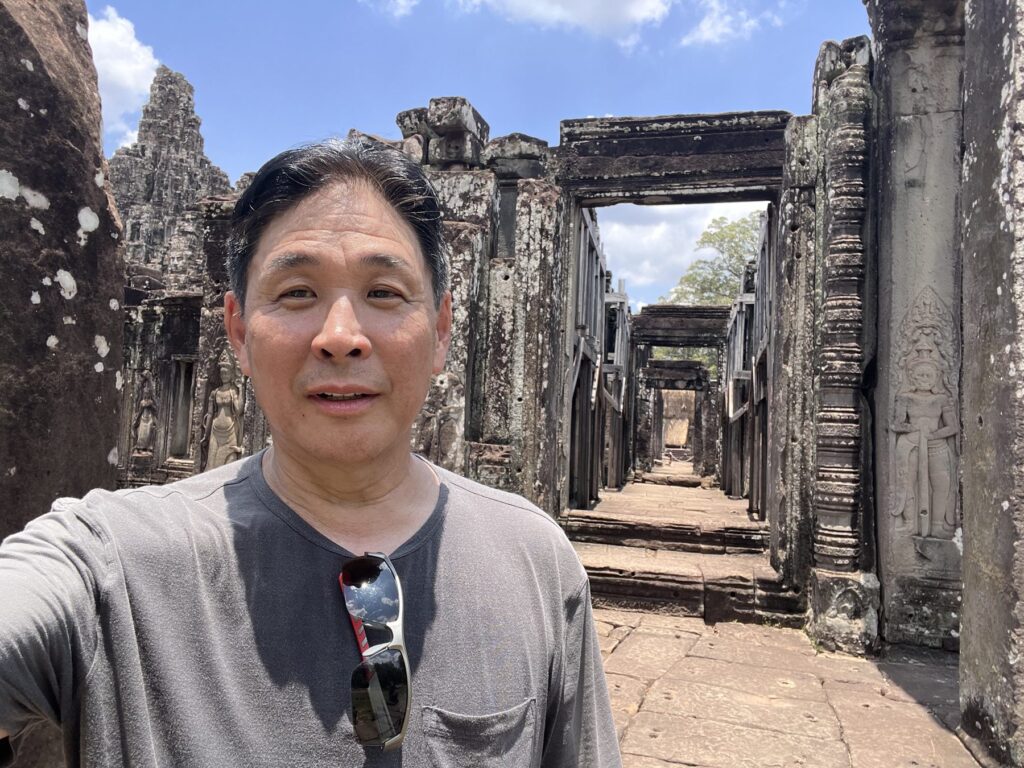 The author taking a selfie in a long stone corridor at the Bayon