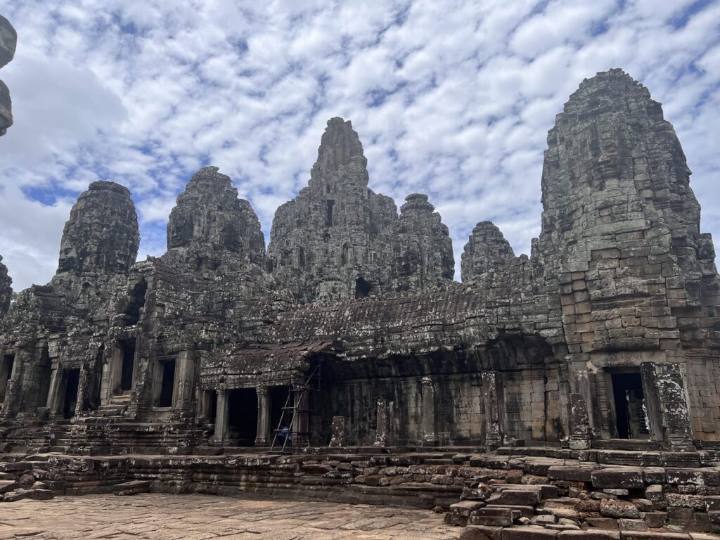 Bayon face towers crowded together under a cloudy sky