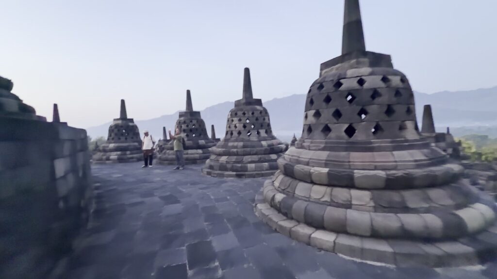 Upper terrace stupas with a volcano outline on the horizon at dawn