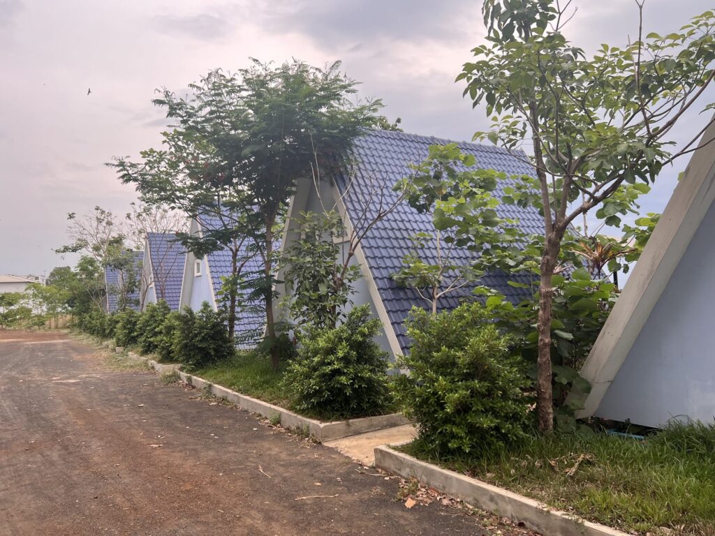 A row of blue-roofed A-frame bungalows at the hotel near Koh Ker