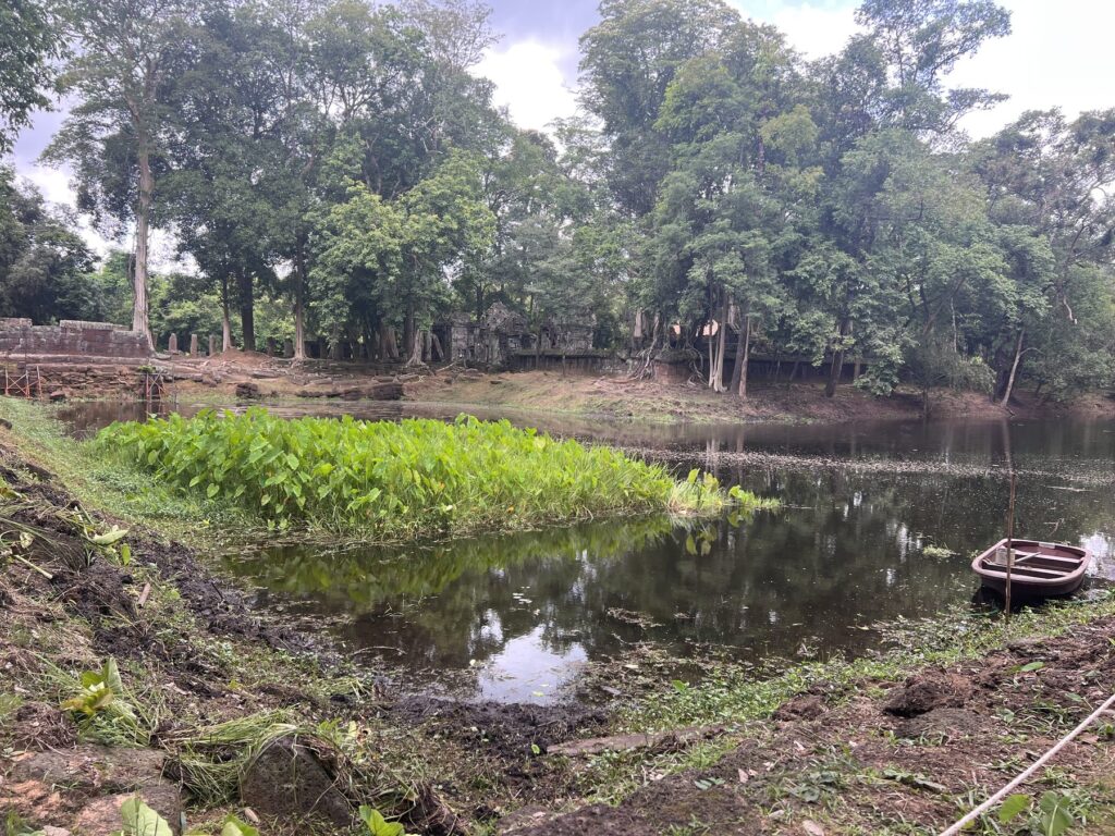The moat around Prasat Thom at Koh Ker, with green plants and a small boat