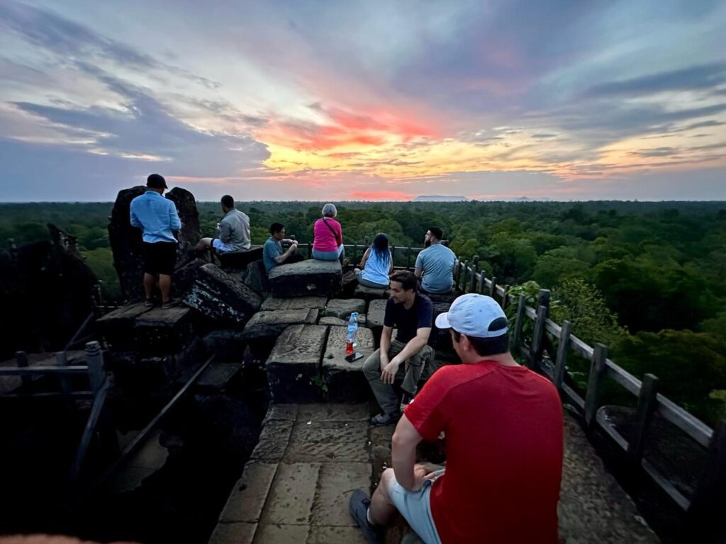 The Maya Exploration Center group sitting among the summit stones of the Koh Ker pyramid at dawn