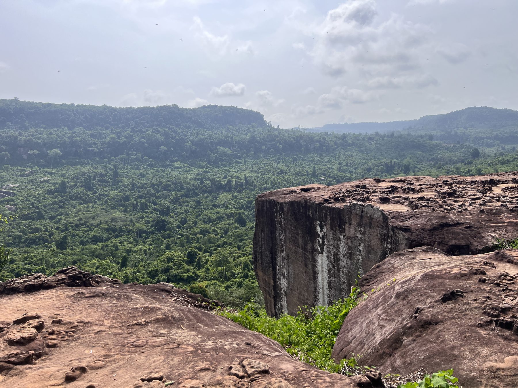 The Amazing Cliff at Poeng Ta Kho on Phnom Kulen, a sandstone ledge above endless green jungle