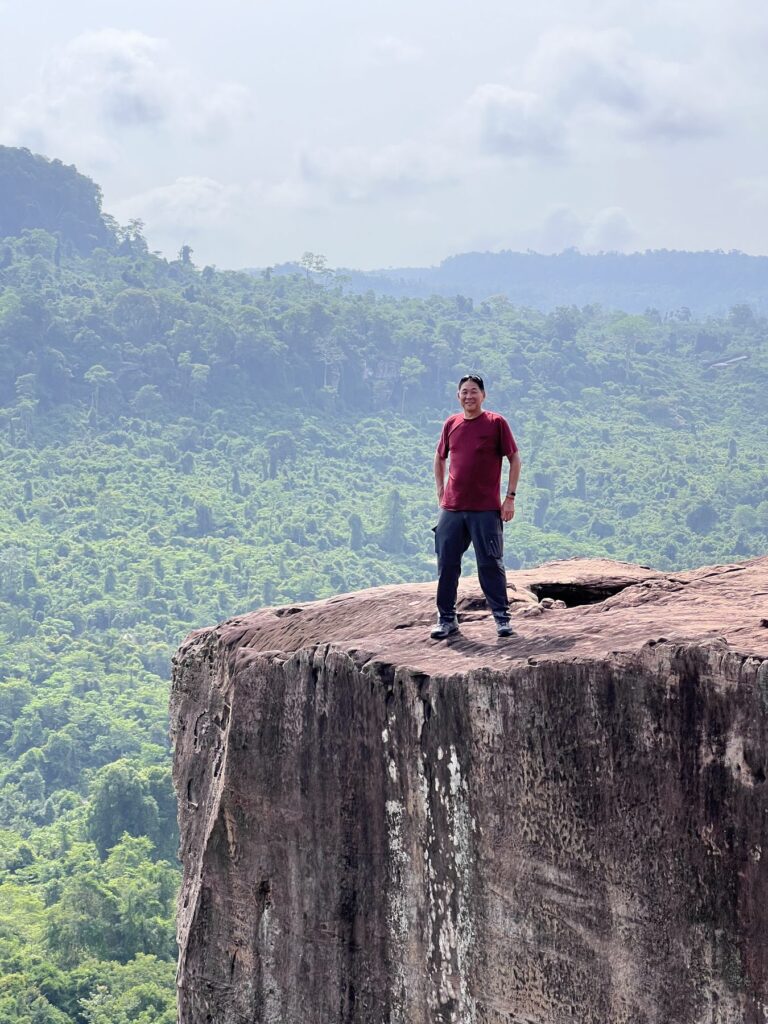 The author standing on top of the rock pillar at the Amazing Cliff above the jungle