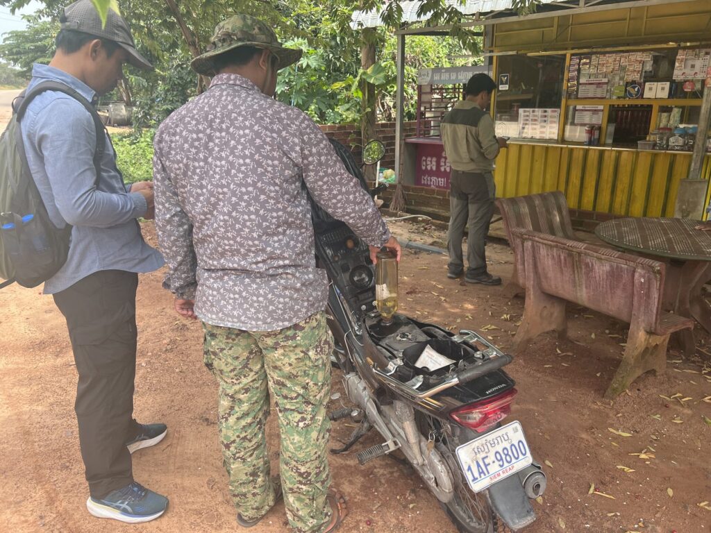 Filling up the motorbikes at a roadside fuel stand before the Kulen trail ride