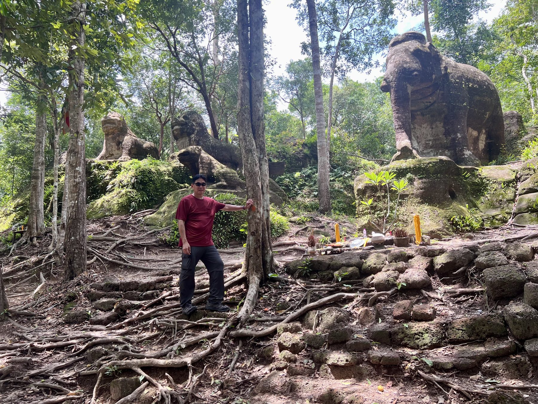 The author standing below the stone elephant and lions at Srah Damrei for scale
