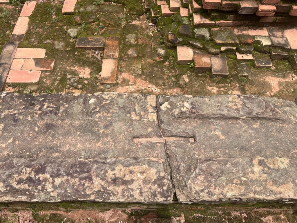A groove cut across the join between two stone blocks at Lolei, with a drill hole at each end