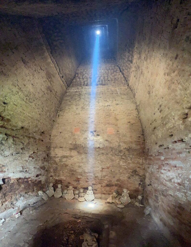 The zenith sunbeam entering the dark chamber of a Lolei tower, lit up by incense smoke