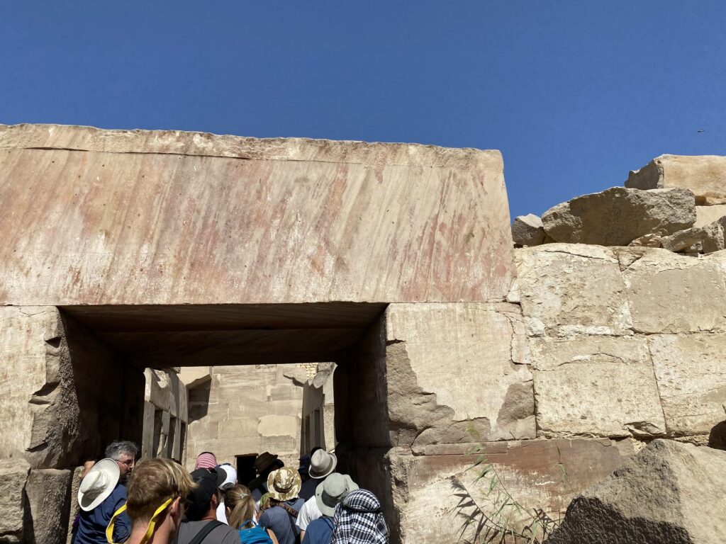 Tour group gathered under a massive stone lintel at the doorway into the Osirion