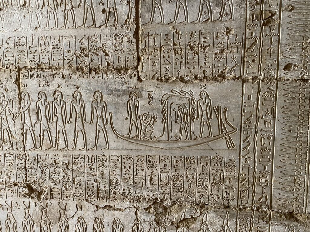 Carved Book of Gates scene with a sun boat on the wall of the Osirion entrance passage